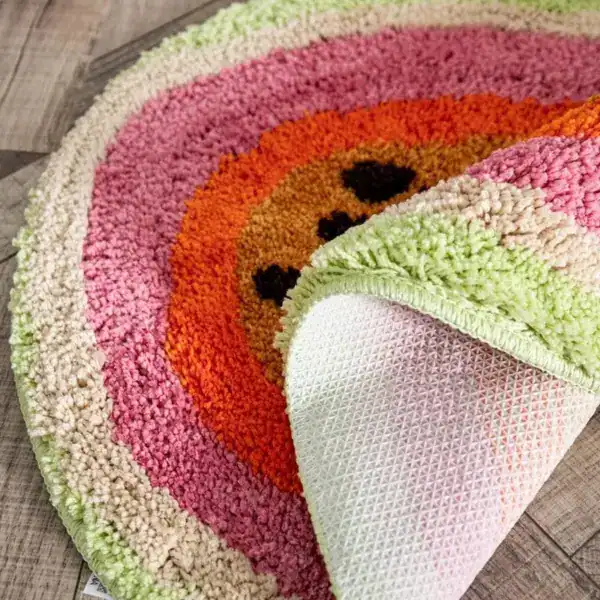 Farbenfroher runder Badteppich mit Regenbogenmuster und weicher Hochflorstruktur.