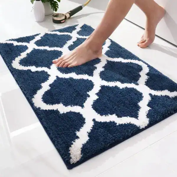 Orientalischer Badteppich mit blau-weißem Muster, weicher Textur und Fußabdruck.