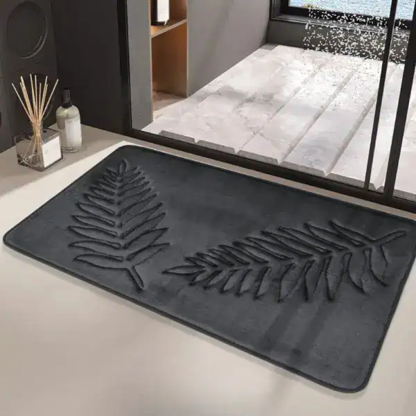 Schwarzer Badteppich mit Pflanzenmotiv, stilvoll im Badezimmer.