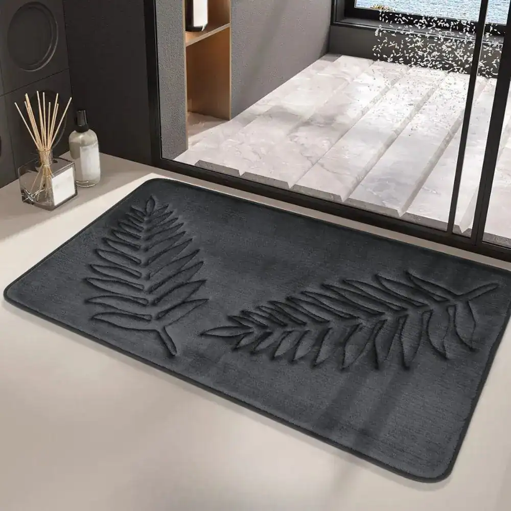Schwarzer Badteppich mit Pflanzenmotiv, stilvoll im Badezimmer.