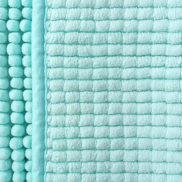 Türkis Badteppich mit rutschfestem Quilt-Design und Pompom-Rand.