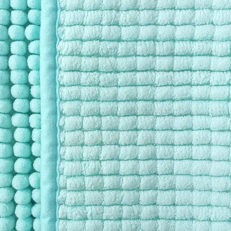 Türkis Badteppich mit rutschfestem Quilt-Design und Pompom-Rand.