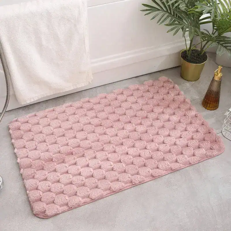 Weicher rosa Badteppich mit hexagonalem Muster für Komfort und Stil im Badezimmer.