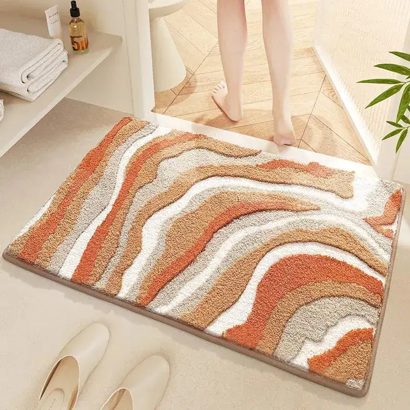 Wellenförmiger Badteppich in Orange-Beige-Tönen, weicher Hochflor für Komfort und Stil im Badezimmer.