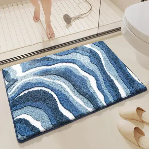 Wellenförmiger Badteppich in Blautönen mit weicher Textur für Komfort und Stil im Badezimmer.