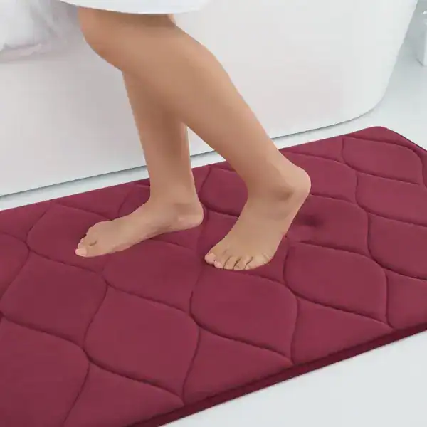 Flauschiger Badvorleger in Rot mit Quastenmuster, ideal für angenehmen Fußkomfort im Badezimmer.