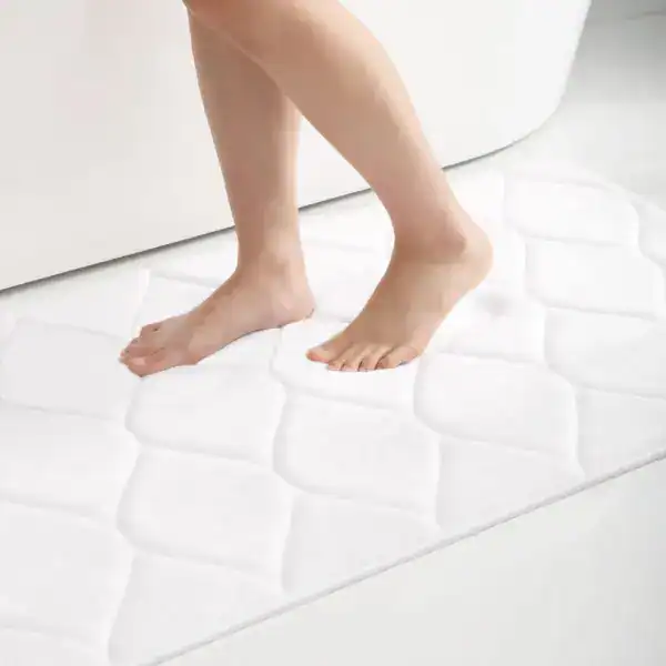 Flauschiger Badvorleger in Weiß mit Quilt-Muster, ideal für angenehmen Komfort nach dem Baden.