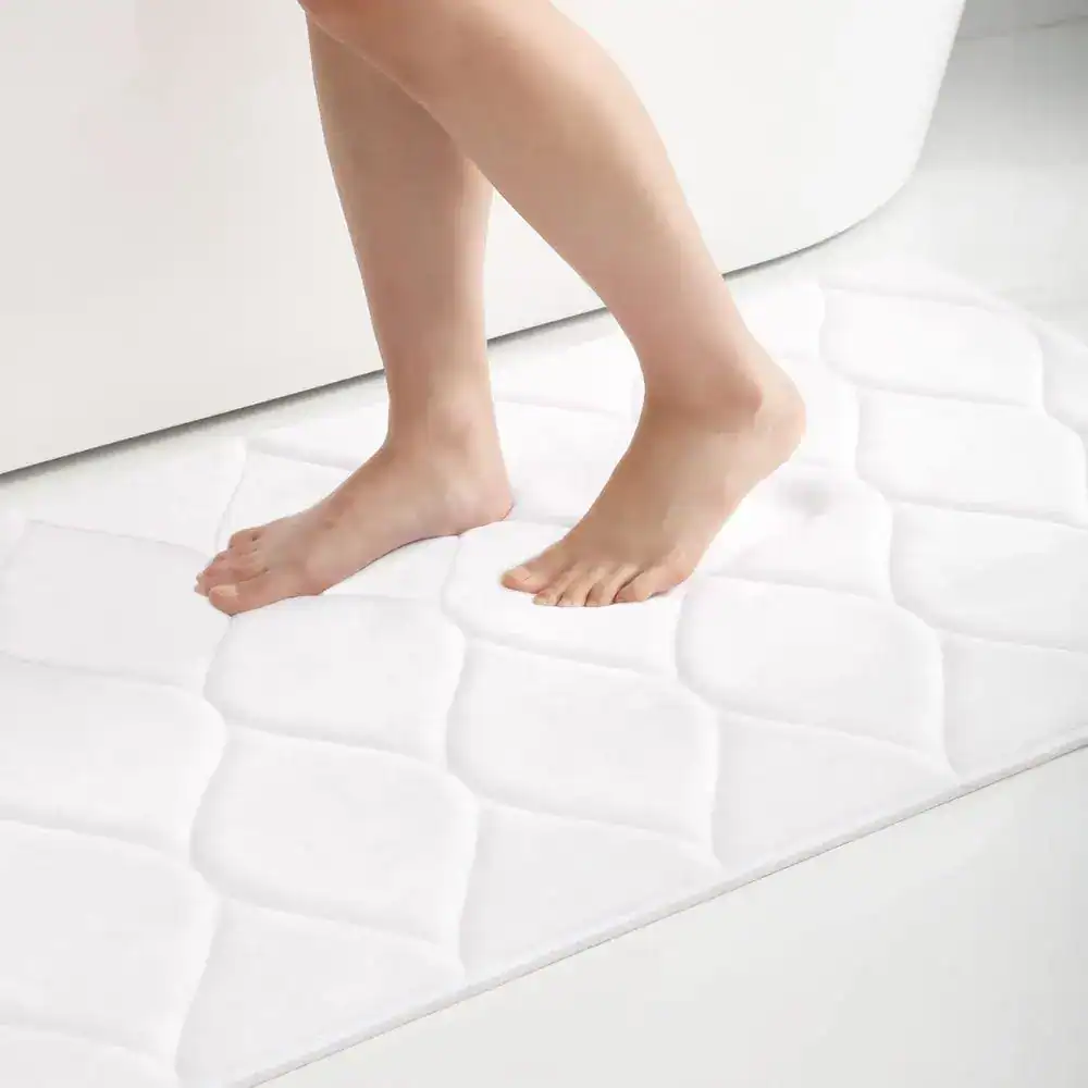 Flauschiger Badvorleger in Weiß mit Quilt-Muster, ideal für angenehmen Komfort nach dem Baden.