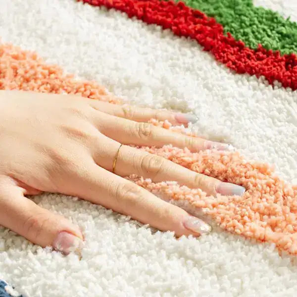 Bunte Badematte mit weichem Hochflor und farbigen Streifen, ideal für Komfort und Stil im Badezimmer.