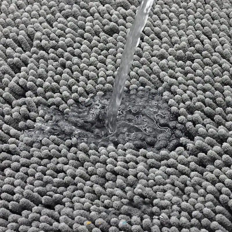 Dunkelgrüne Badematte mit Wasserstrahl, hochwertig, schnell trocknend und rutschfest.