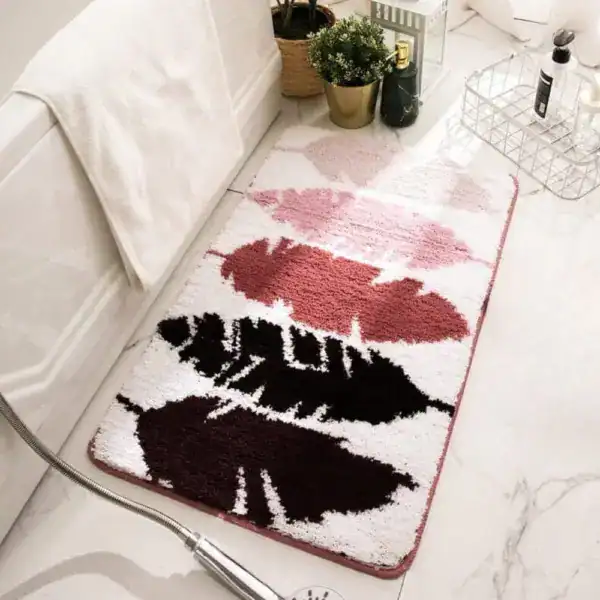 Gemusterte Badematte mit Blättermotiv in Rosa, Rot und Schwarz auf weißem Grund.