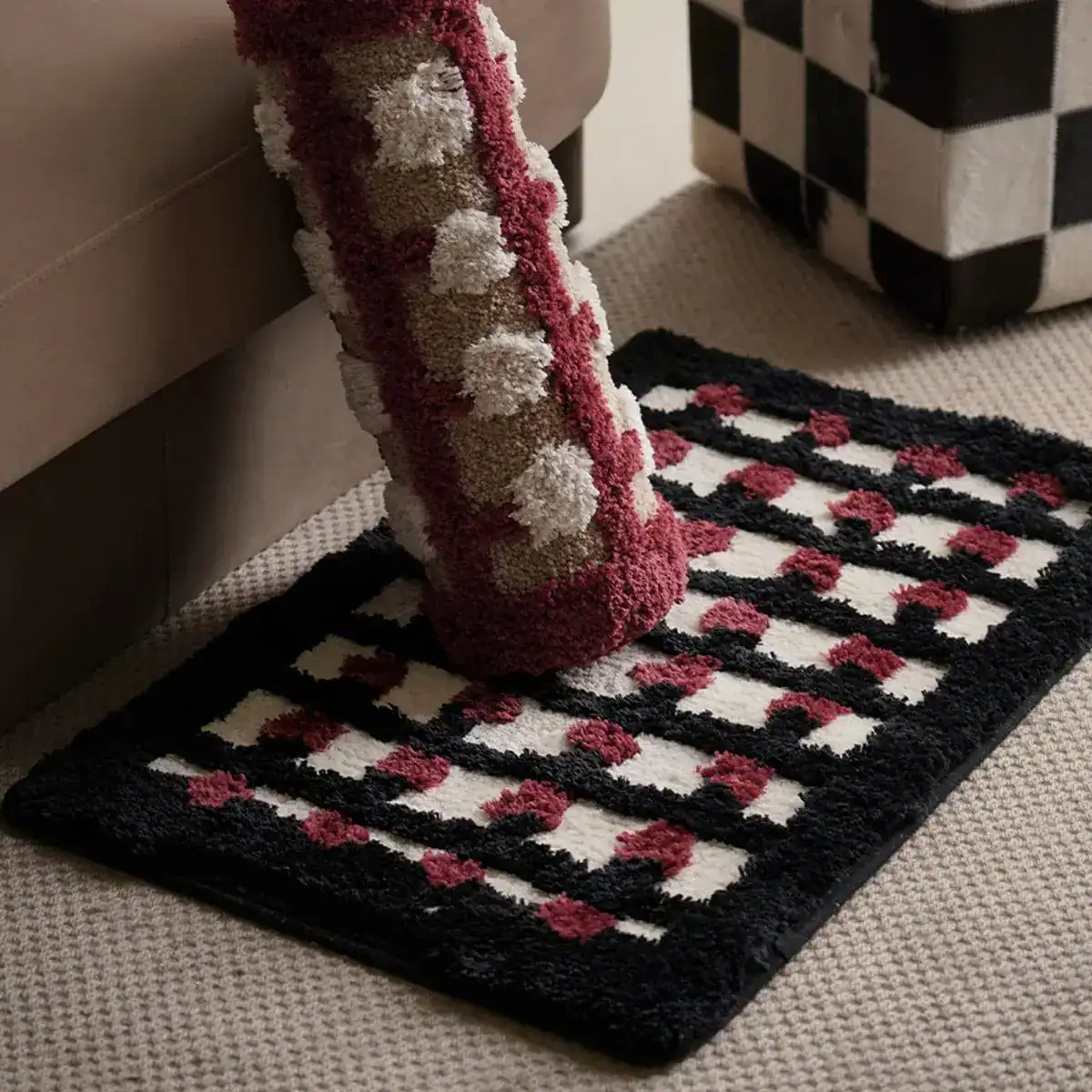 Geometrische Badematte mit schwarz-weiß-rotem Muster und flauschigem Hochflor.