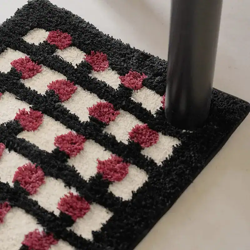 Geometrische Badematte mit schwarz-weiß-rotem Muster und hochflorigem Design.