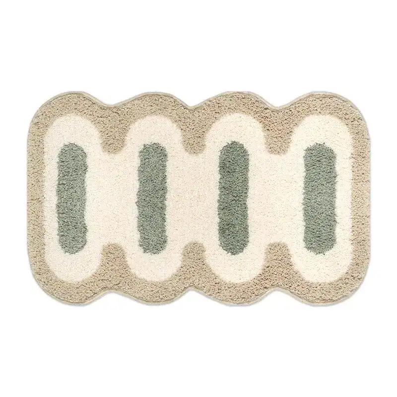 Kleine Badematte mit wellenförmigem Rand und grün-cremefarbenem Muster.
