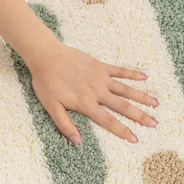 Kleine Badematte mit weichem Hochflor und geometrischem Muster in Pastelltönen.