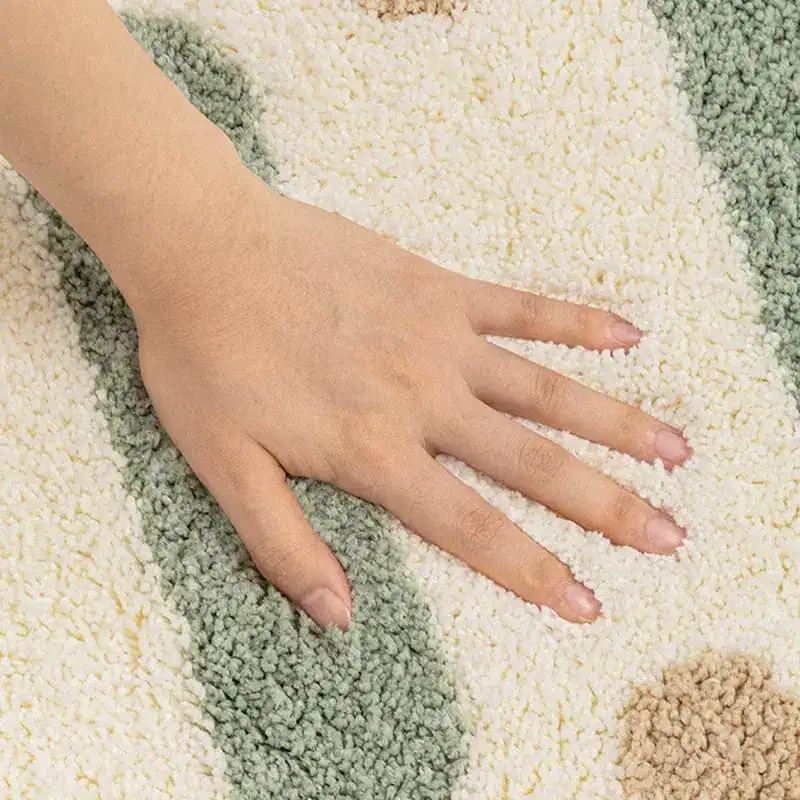 Kleine Badematte mit weichem Hochflor und geometrischem Muster in Pastelltönen.