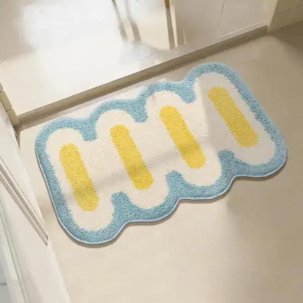 Kleine Badematte mit wellenförmigem Rand, blau-weiß-gelb gestaltet für Badezimmer.