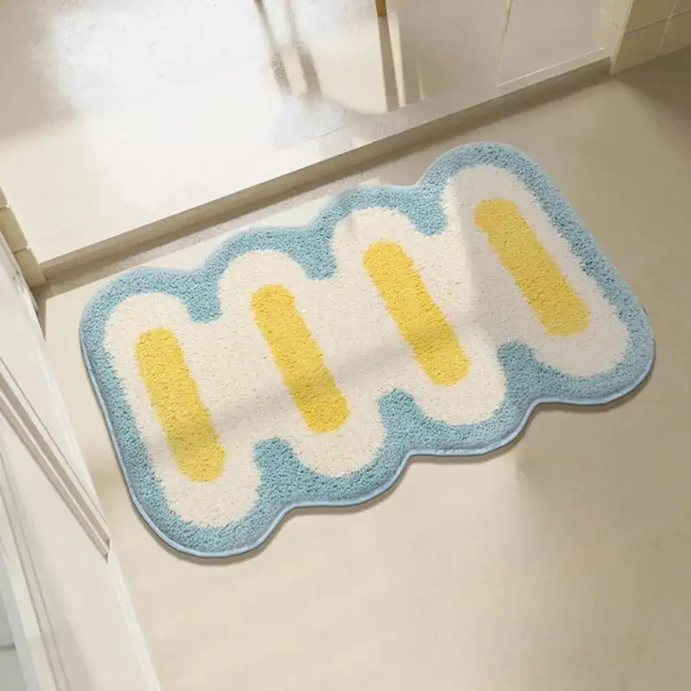 Kleine Badematte mit wellenförmigem Rand, blau-weiß-gelb gestaltet für Badezimmer.