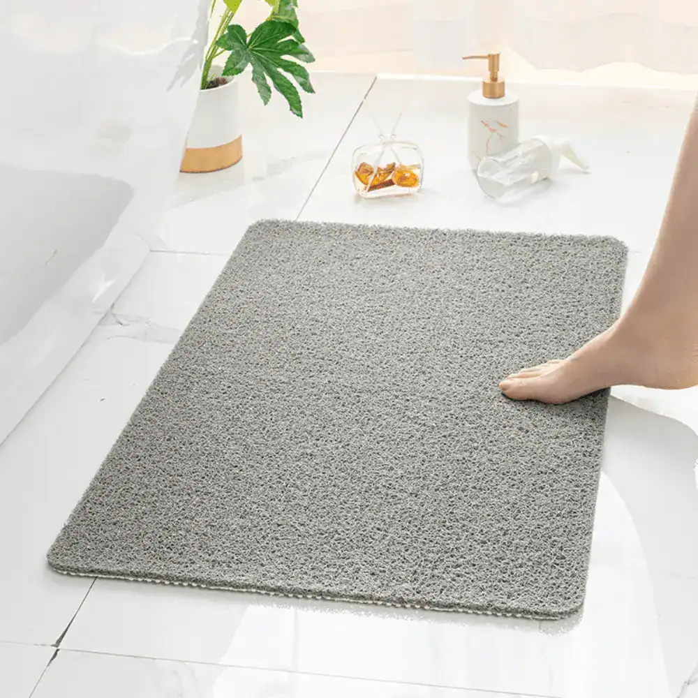 Rutschfeste Badematte für Dusche, grau, weiches Material, Fuß auf Matte, Badezimmer.