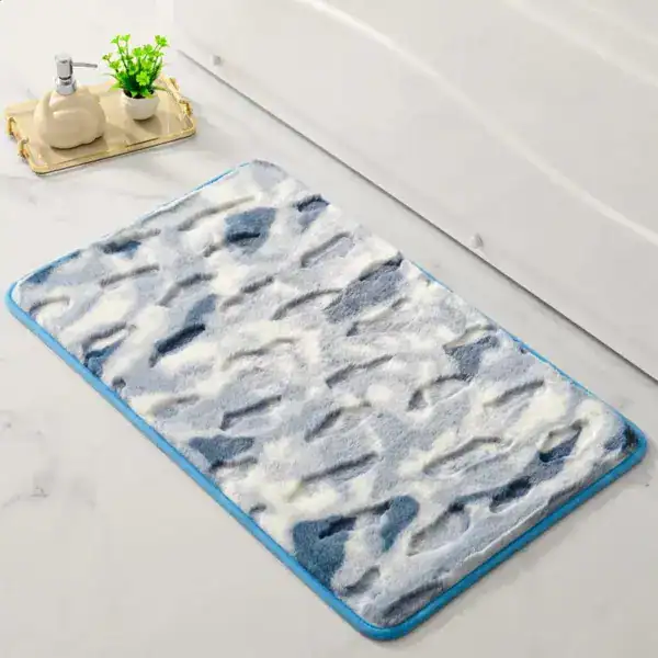Shaggy Badteppich mit blau-weißem Muster und blauer Bordüre für Komfort im Badezimmer.