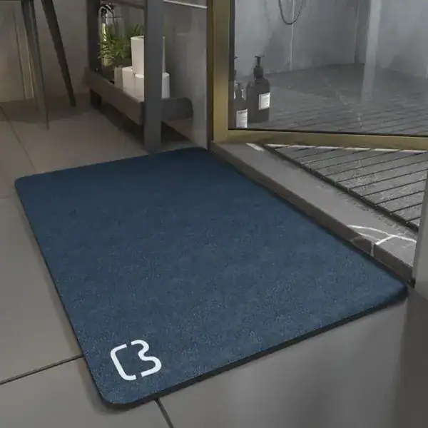Superabsorbierende Badematte in Blau mit Logo, ideal für feuchte Badezimmer.