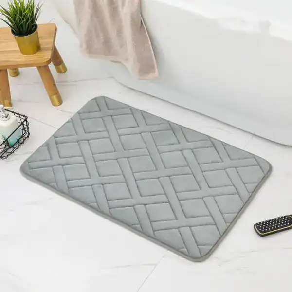 Weichschaum Badematte grau mit Quilt-Muster vor Badewanne.