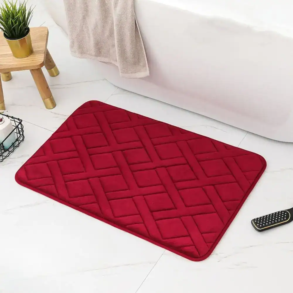 Rot weichschaum Badematte mit Quiltmuster vor weißer Badewanne.